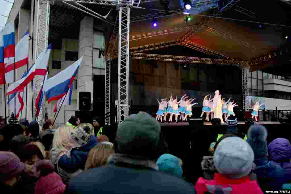 Сцену прикрасили прапорами Росії та Криму. Тим, хто зібрався на площі, демонстрували вистави