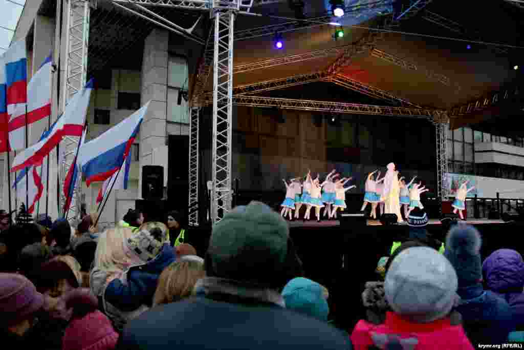 Сцену украшали флаги России и Крыма. Собравшимся на площади детям и взрослым показывали представления