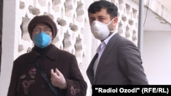 Люди в защитных масках у здания суда в Душанбе. 13 апреля 2020 года.