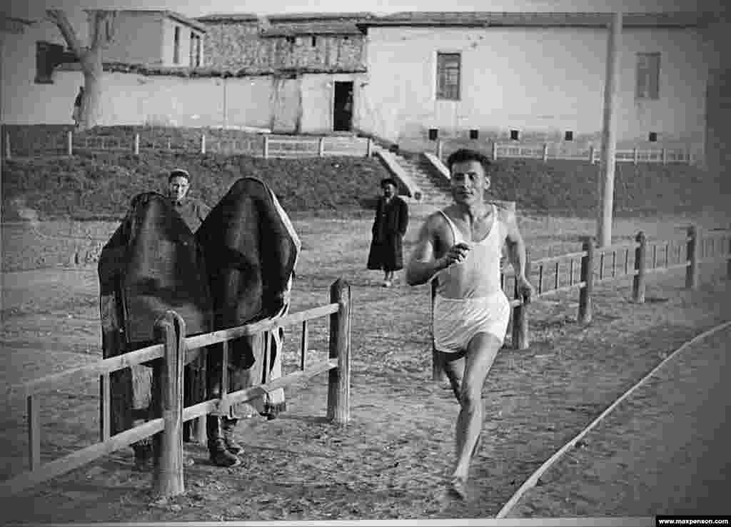 One of Penson&#39;s early photographs showing a runner cheered by burqa-clad women. After winning a camera as a reward for excellence in teaching, the young immigrant threw himself into photography.