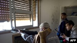 Libyan rebel fighters fire on loyalist snipers from a window in a trashed house on Tripoli Street in Misurata on April 20.