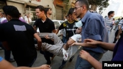 Мұхаммед Мурсидің жақтастары жараланған шерушіні әкетіп барады. Каир, 16 тамыз 2013 жыл 