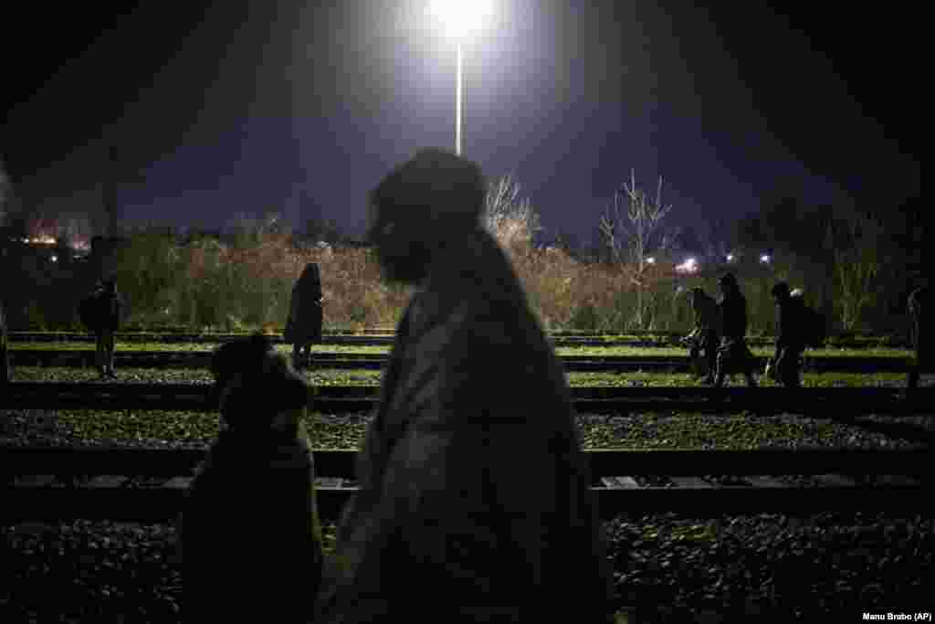 Një grup migrantësh ecin pranë hekurudhës në kufirin midis Bosnjës dhe Serbisë.