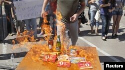Участники акциив Киеве сжигают товары, произведённые в России