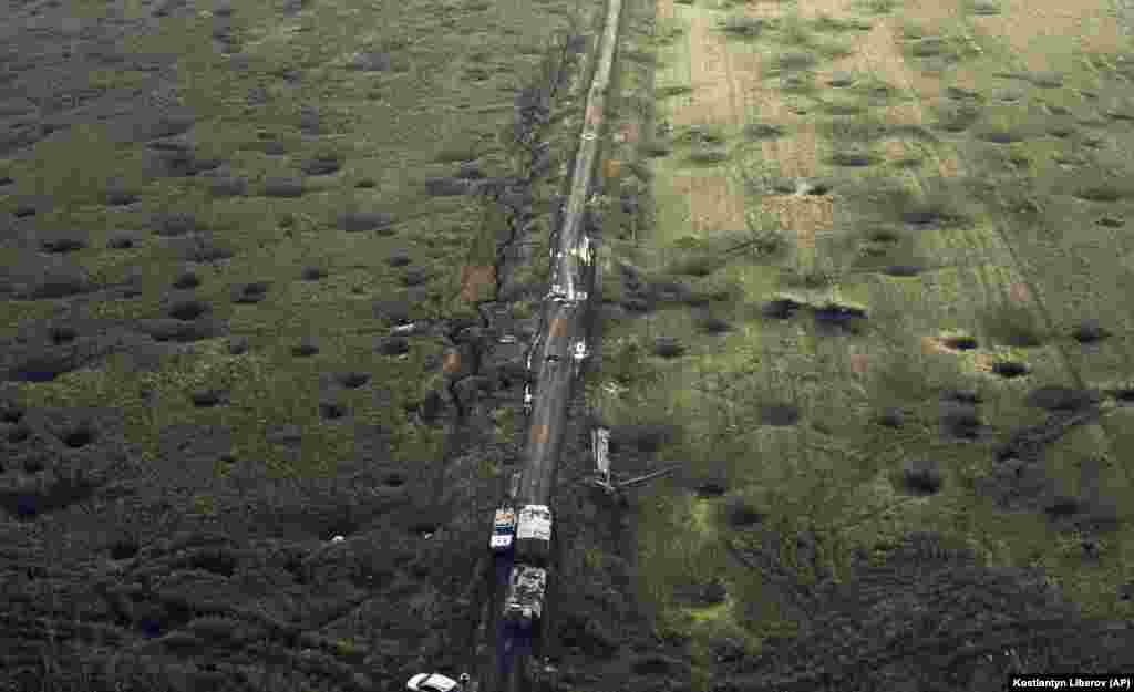 The scars of war are evident from above: a field is covered in artillery craters and destroyed military hardware litters a road. &nbsp;