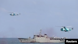 Iranian helicopters fly as a navy ship is seen during a graduation ceremony for Iranian navy cadets in the Caspian Sea, September 30, 2015