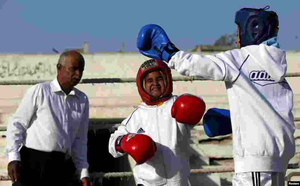 Tabia (R), 12, fights against Aamna, 11, during the Sindh Junior Sports Association Boxing Tournament in Karachi.