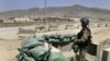 An Afghan soldier stands guard at the gate of an air-force compound in Kabul in April 2011.