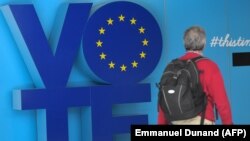 A man walks past a "Vote" sign at the an station near the European Parliament in Brussels on May 24.