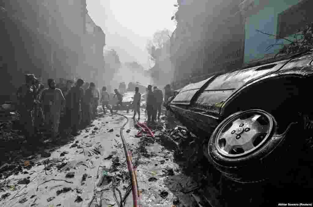 Rescue workers gather at the site of a passenger-plane crash in a residential area near the international airport in Karachi, Pakistan, on May 22. (Reuters/Akhtar Soomro)