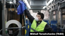 An public-transport employee wearing a protective mask sanitizes a bus over coronavirus fears in Moscow. 