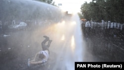 Armenia -- A protester is hit by a jet of water released from a riot police vehicle during a rally against a recent decision to increase the tariff on electricity, in Yerevan, Armenia, June 23, 2015. 