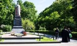 Пам'ятник радянському генералу Ватутіну, облитий червоною фарбою, і св’ященник Московського патріархату. Київ, 18 травня 2017 року