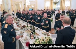 Президент РФ Володимир Путін (спиною на першому плані) на урочистому прийомі в Кремлі на честь випускників військово-навчальних закладів ФСО РФ, Міноборони РФ, МНС РФ, ФСБ, Росгвардії та організацій вищої освіти МВС Росії та ФСВП Росії, архівне фото