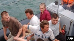 Russian officials and rescuers with crewmembers of the "Arctic Sea" near Cape Verde on August 19.