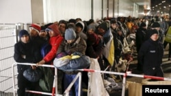 Migrants queue on a street to enter the compound outside the Berlin Office of Health and Social Affairs (LAGESO) for their registration process in Berlin, December 2015. 