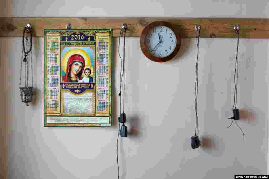 A calendar with the image of Mary hangs alongside mobile phone chargers in the monastery&#39;s living quarters.