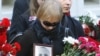 A mourner carries a portrait of Aleh Byabenin during his funeral in Minsk today.