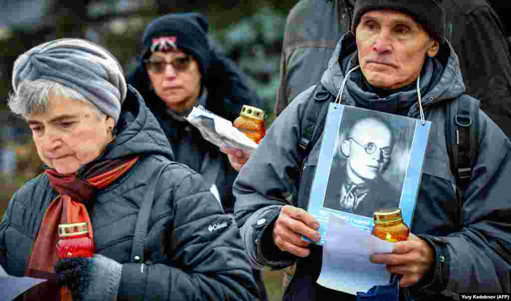 People carry candles and a picture near the Solovki Stone monument in front of the Federal Security Service building in central Moscow on October 29. (AFP/Yury Kadobnov)