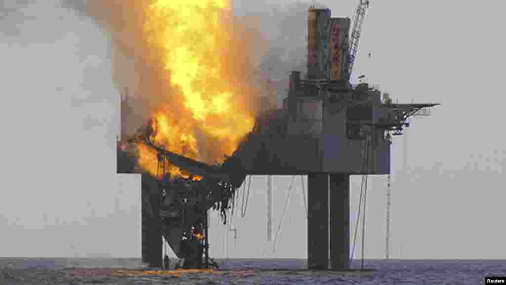 A shallow-water Gulf of Mexico drilling rig partially collapsed off the coast of Louisiana after catching fire because of a ruptured natural-gas well. The well released natural gas, but no oil, according to authorities. No one was on board when the rig caught fire. (Reuters)