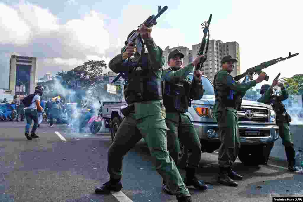 Члени Боліварської національної гвардії, які приєдналися до лідера опозиції Хуана Гуайдо, стріляють у повітря, щоб відлякати силовиків-прибічників президента Ніколаса Мадуро, які приїхали, щоб розігнати демонстрацію неподалік військової бази Ла Карлота в Каракасі