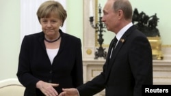 Президент России Владимир Путин протягивает руку канцлеру Германии Ангеле Меркель. Москва, 10 мая 2015 года.