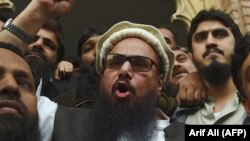 PAHafiz Saeed (center) speaks to the media outside a court in Lahore in November 2017.