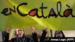 Демонстранты держат плакат с надписью «по-каталонски» во время протеста против планов правительства по реформированию использования каталанского языка