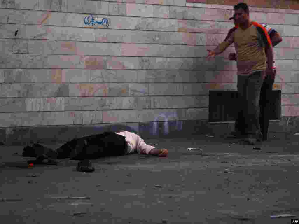 A wounded man lies on the ground after the militia fired into the crowd. 
