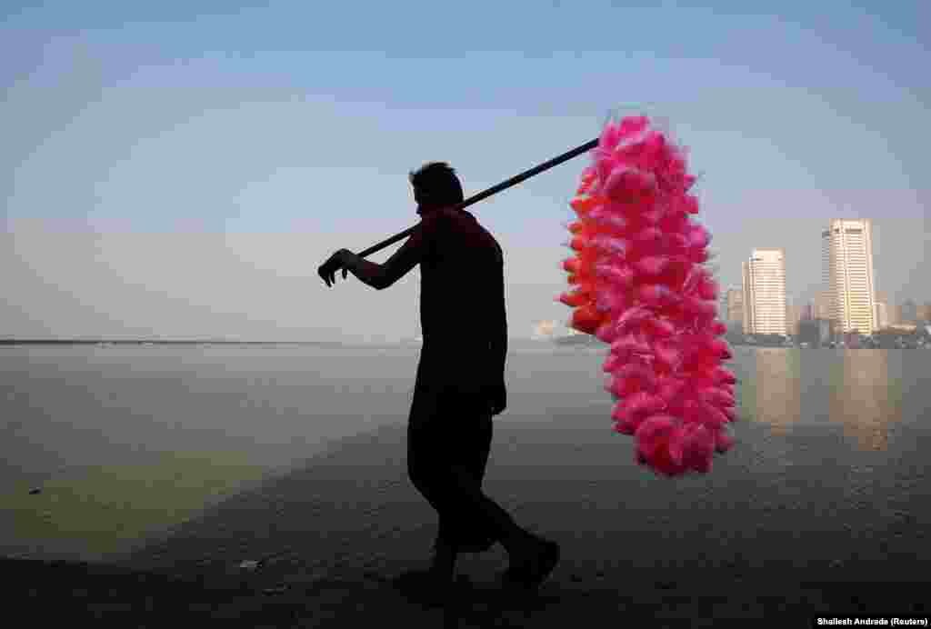 A man selling colored cotton candy walks on the shores of the Arabian Sea in Mumbai, India. (Reuters/Shailesh Andrade) 