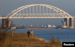 A Russian cargo ship is seen beneath the Kerch Bridge connecting the Russian mainland with the Crimean Peninsula on November 25