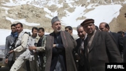 Afghan First Vice President Muhammad Qasim Fahim (right, in hat) tours and avalanche site in the Salang Pass, north of Kabul, with President Hamid Karzai (center) in 2010.