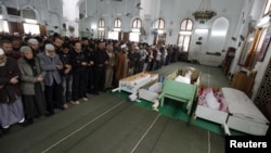 Mourners pray next to the bodies of victims of the violence during their funerals in Port Said.