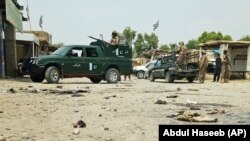 Pakistani troops guard the site of a suicide attack at an election rally in Bannu on July 13.