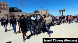 Місцеві жителі несуть тіло військового з урядових сил, загиблого внаслідок боїв за Тріполі, Лівія, 8 квітня 2019 року