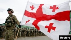 A Georgian soldier holds his country's national flag as he and others take part in a launching ceremony ahead of the joint Georgian-U.S. military training exercises "Agile Spirit 2013" on March 18.