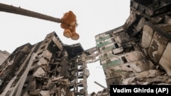 Плюшевый мишка висит на ветке поврежденного дерева возле жилого дома, разрушенного во время масштабном вторжении России в Украину. Поселок Бородянка Киевской области, 5 апреля 2022 года 