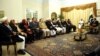 Pakistani Prime Minister Raja Pervez Ashraf (right) talks to members of the Afghan High Peace Council, which is chaired by Salahuddin Rabbani, in Islamabad on November 12.