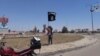 احد مسلحي داعش يرفع راية التنظيم في الرمادي