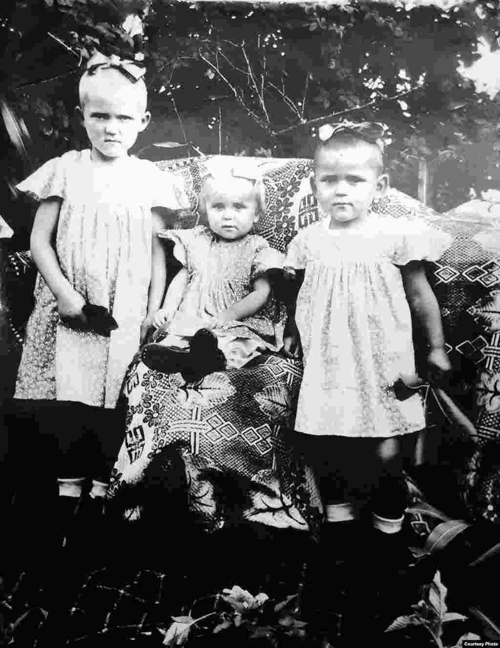 (de la dreapta spre stânga) Ekaterina Iajgunovici cu fratele Nikolai și sora Petrunelea. &bdquo;Fratele e îmbrăcat în rochie. Mama spunea: &laquo;De ce să cumpărăm haine noi? Le va purta pe cele ale fetelor&raquo;&rdquo;, își amintește Ekaterina. Stîrcea, circa 1950