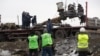 Members of a Dutch recovery team look on as wreckage from Malaysia Airlines Flight 17 -- which is thought to have been downed by Russian-backed rebels who still control the area around the crash site -- is loaded onto a truck near Hrabove, in eastern Ukraine. The debris will be moved to Kharkiv, then on to the Netherlands, which is leading the investigation into the July 17 incident. (AFP/Menahem Kahana)