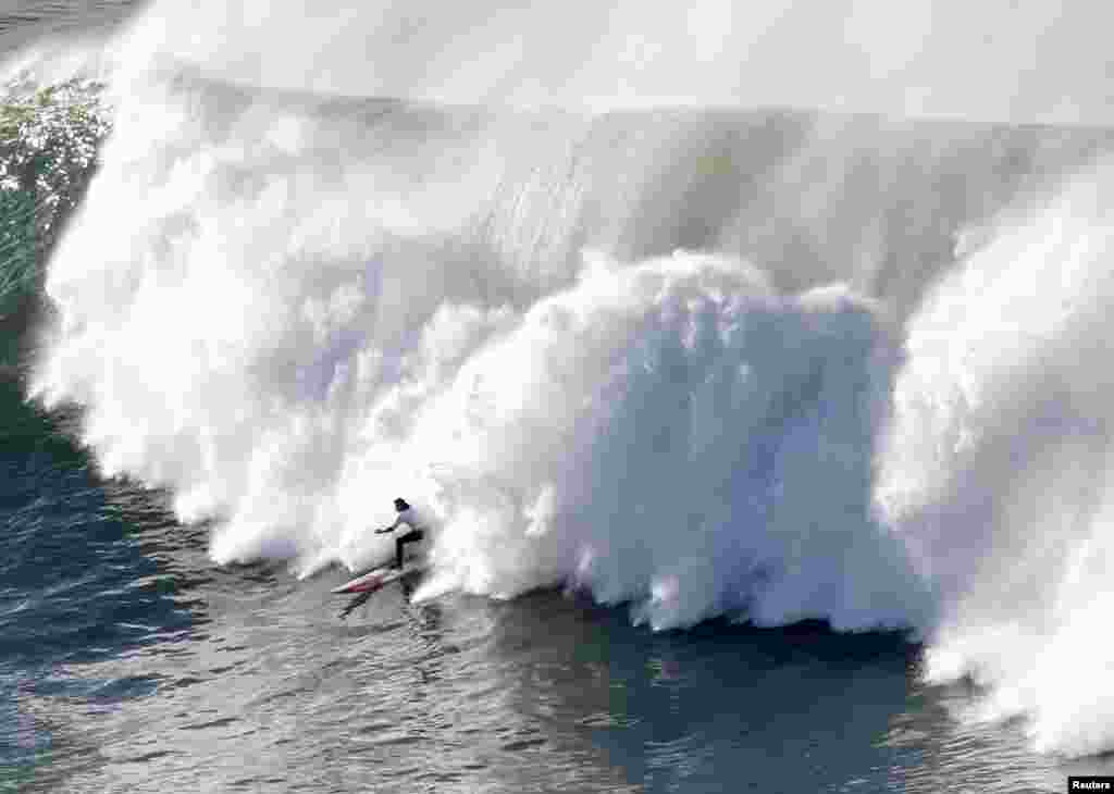 A surfer rides a wave during the Punta Galea Big Wave Challenge in Punta Galea, Spain. (Reuters/Joseba Etxaburu)