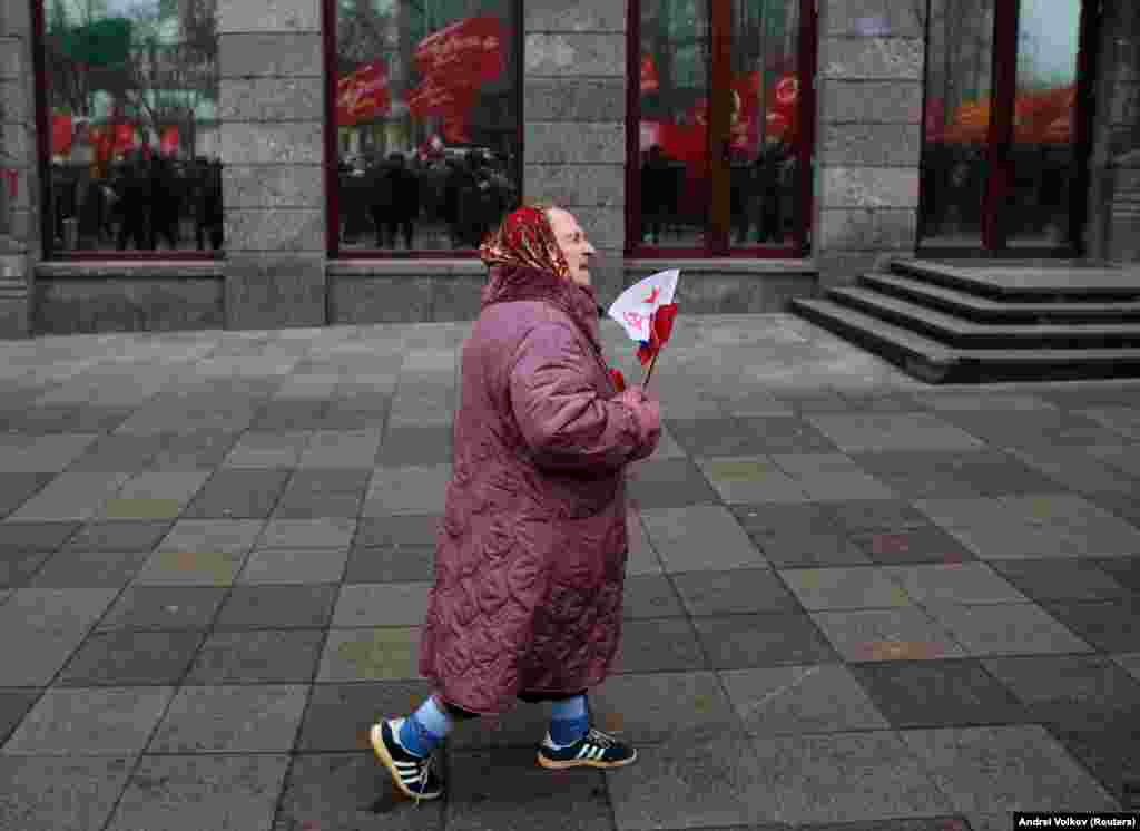 An elderly woman carries flags during a rally held by the Russian Communist Party to mark the Red October revolution&#39;s centenary in central Moscow on November 7. (Reuters/Andrei Volkov)