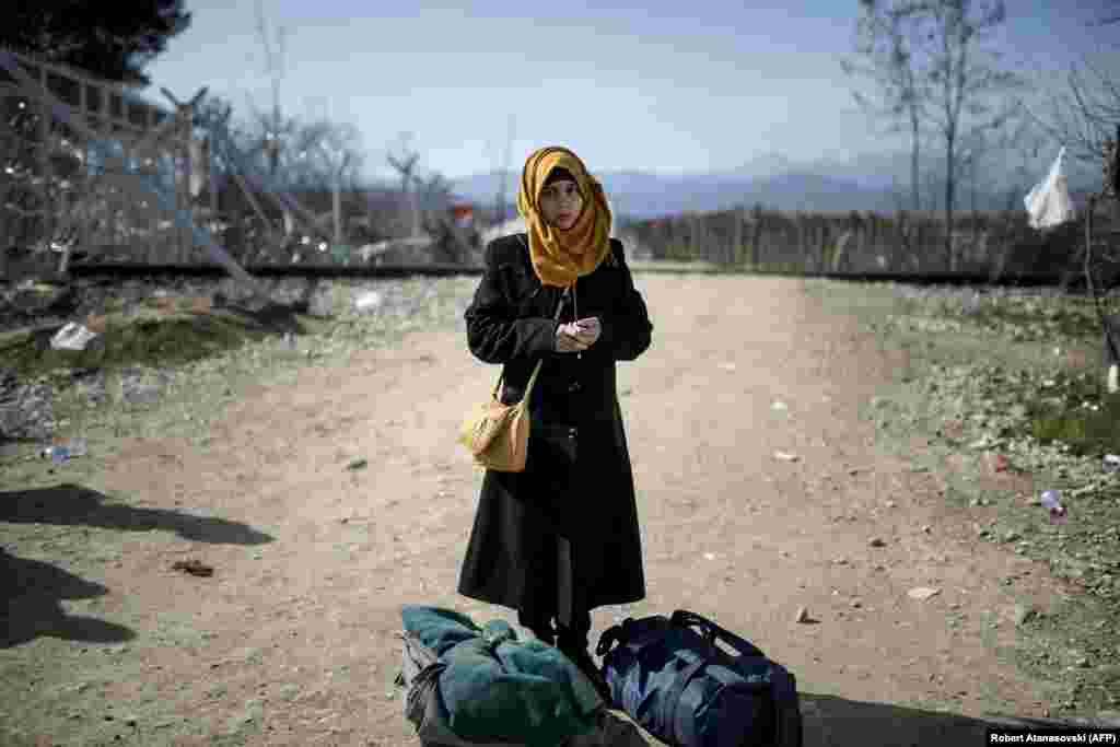 A young migrant woman from Syria stands with her bags after crossing the Greek-Macedonian border. (AFP/Robert Atanasovski)