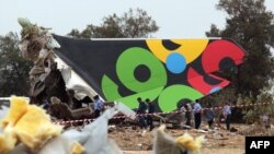 Security forces and rescue teams inspect the debris of the plane near the Tripoli airport.