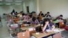 Students in an Iranian school are taking the final exam at third grade of high school. Undated.