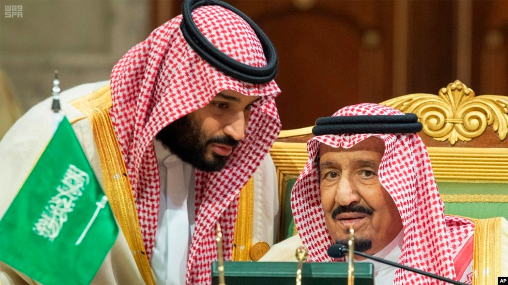 Saudi Crown Prince Mohammed bin Salman, left, speaks to his father, King Salman, right, at a meeting of the Gulf Cooperation Council in Riyadh, Saudi Arabia, Sunday, Dec. 9, 2018. Leaders of Gulf