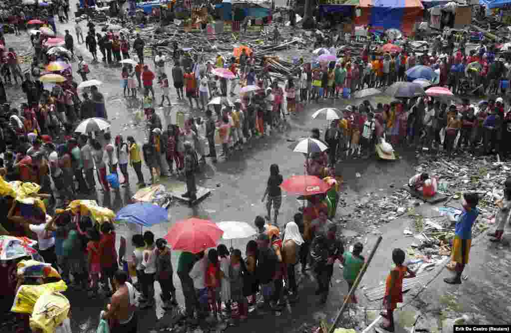 Филиппинцы выстраиваются в очередь за едой и водой в городе Таклобан, в центральной части Филиппин, в связи с последствиями тайфуна Хайян 14 ноября 2013 года. Тайфун привел к многотысячным жертвам и эвакуации сотен тысяч людей.