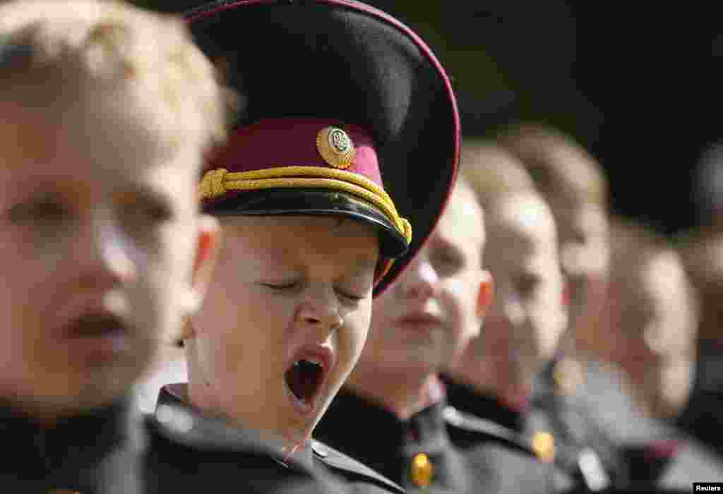 A first-grader at a cadet's lyceum yawns as he attends a ceremony to mark the start of the new school year in Kyiv. (Reuters/Valentyn Ogirenko) 