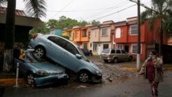 Žena sa zaštitnom maskom prolazi pored uništenih automobila u tropskoj oluji 'Amanda', San Salvador, El Salvador, 31 maj 2020.